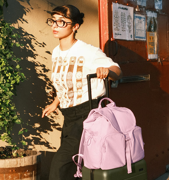 Two women posing for a photo both wearing the Away featherlight Cargo Pack