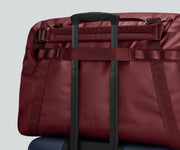 Active Duffle 70L shown on top of a checked Away suitcase
