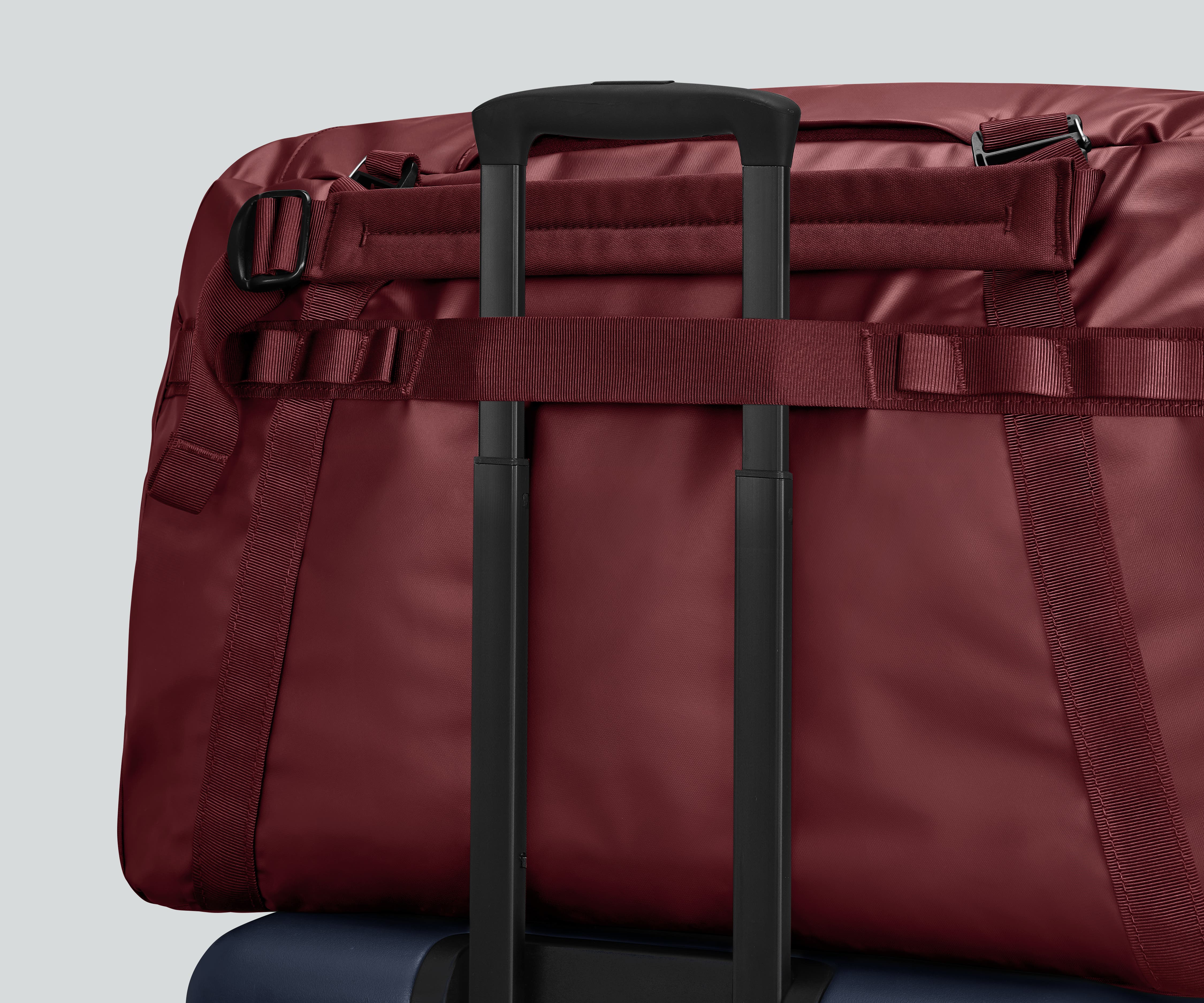 Active Duffle 70L shown on top of a checked Away suitcase