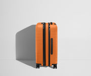 Side product view of The Bigger Carry-On Flex suitcase in Sorbet Orange shown fully expanded