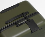 The Trunk suitcase in Olive Green shown shown from above highlighting TSA-approved combination lock and recycled leather luggage tag