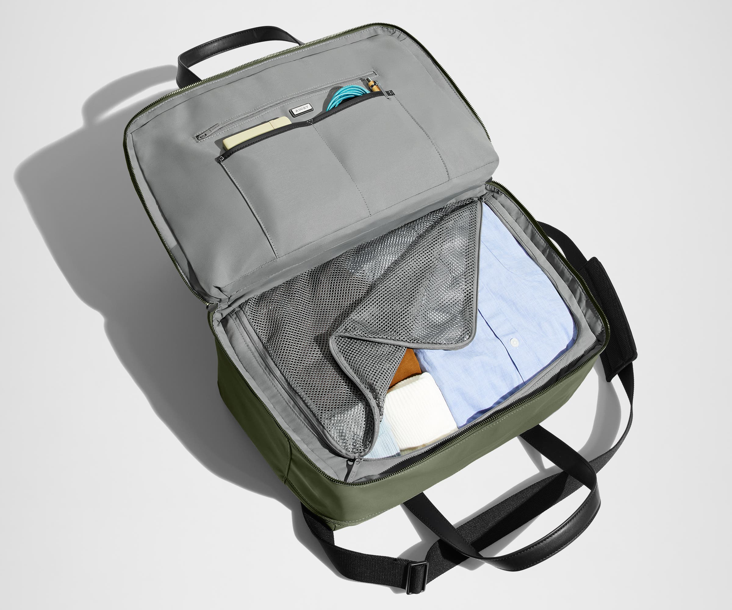 Main interior packed with clothing. Slip pockets packed with a notebook and charging cords