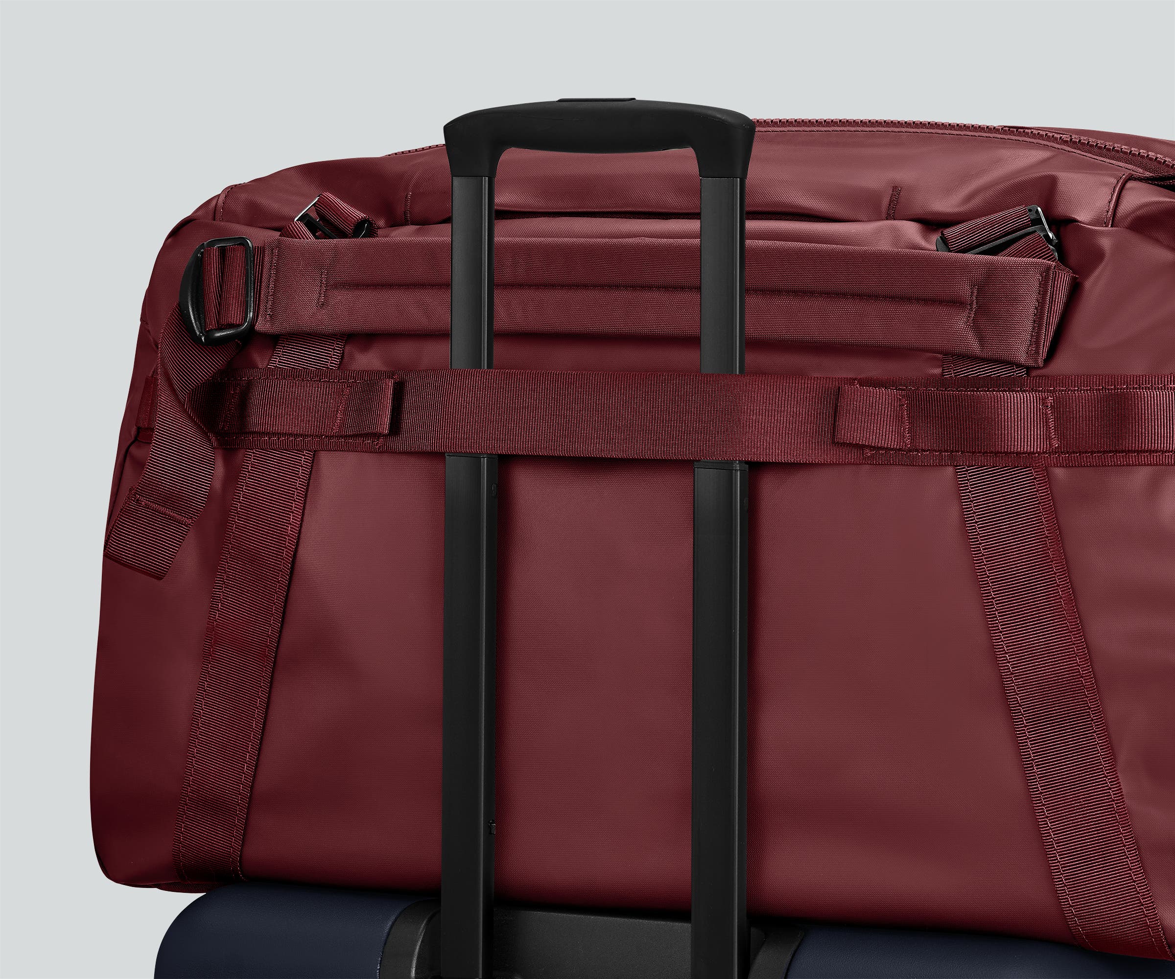 55L duffle bag secured to an Away suitcase by the trolley sleeve
