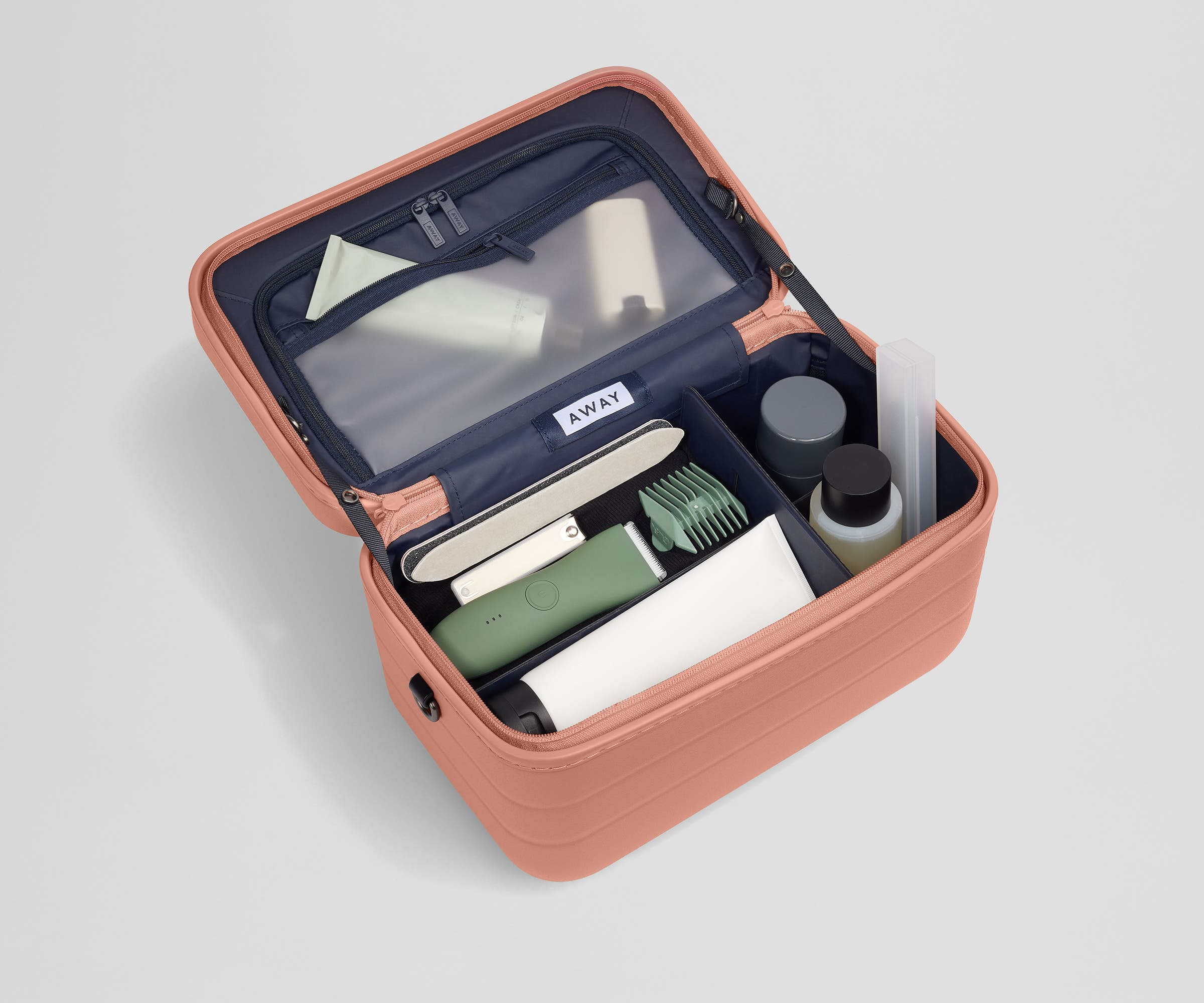 Train case packed with multiple grooming essentials, including a razor, nail care, and lotions