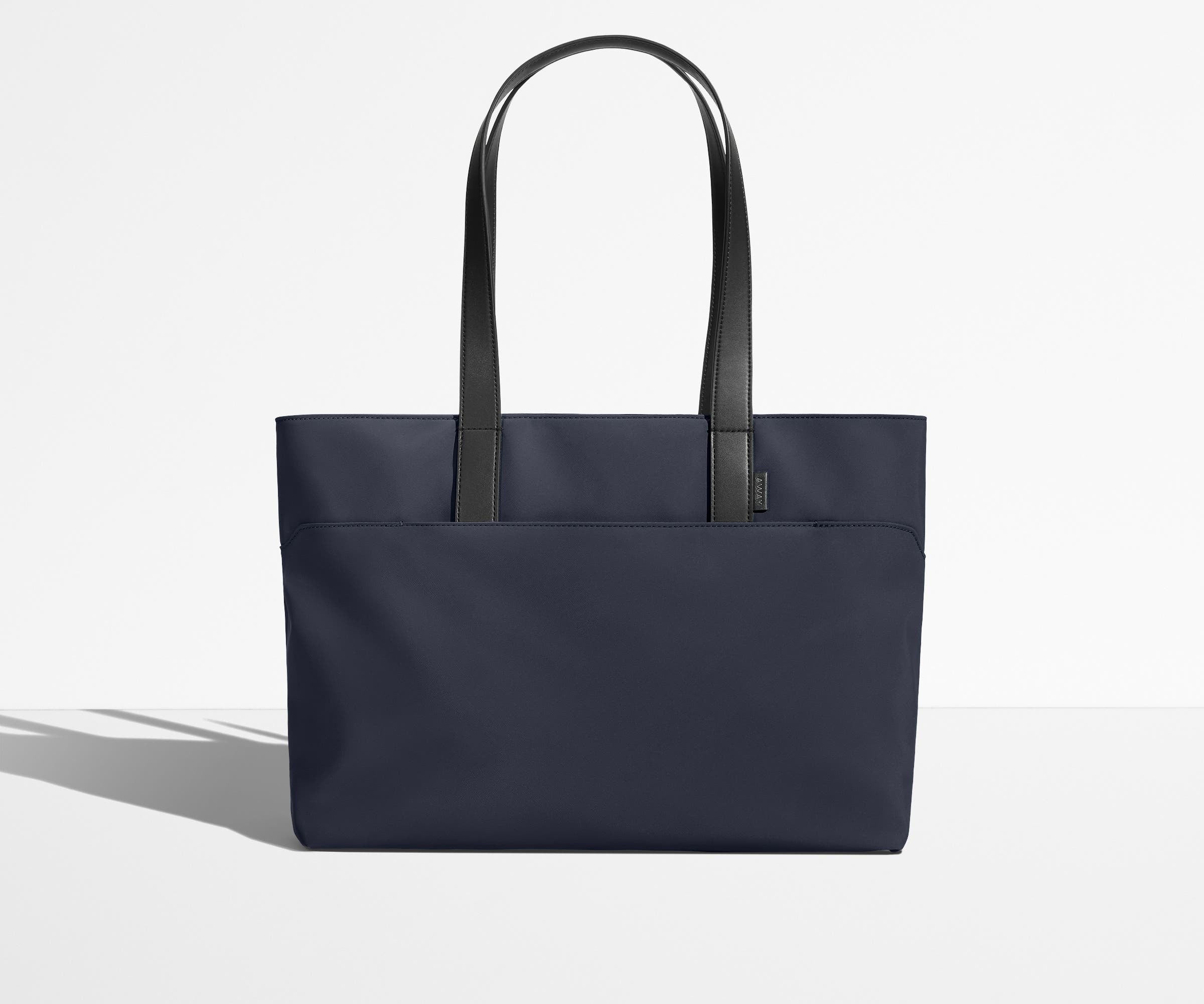 Front view of The Everywhere Tote with its leather handles up