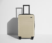 Front product view of The Bigger Carry-On Flex suitcase in Salt White (Gloss) with raised handle