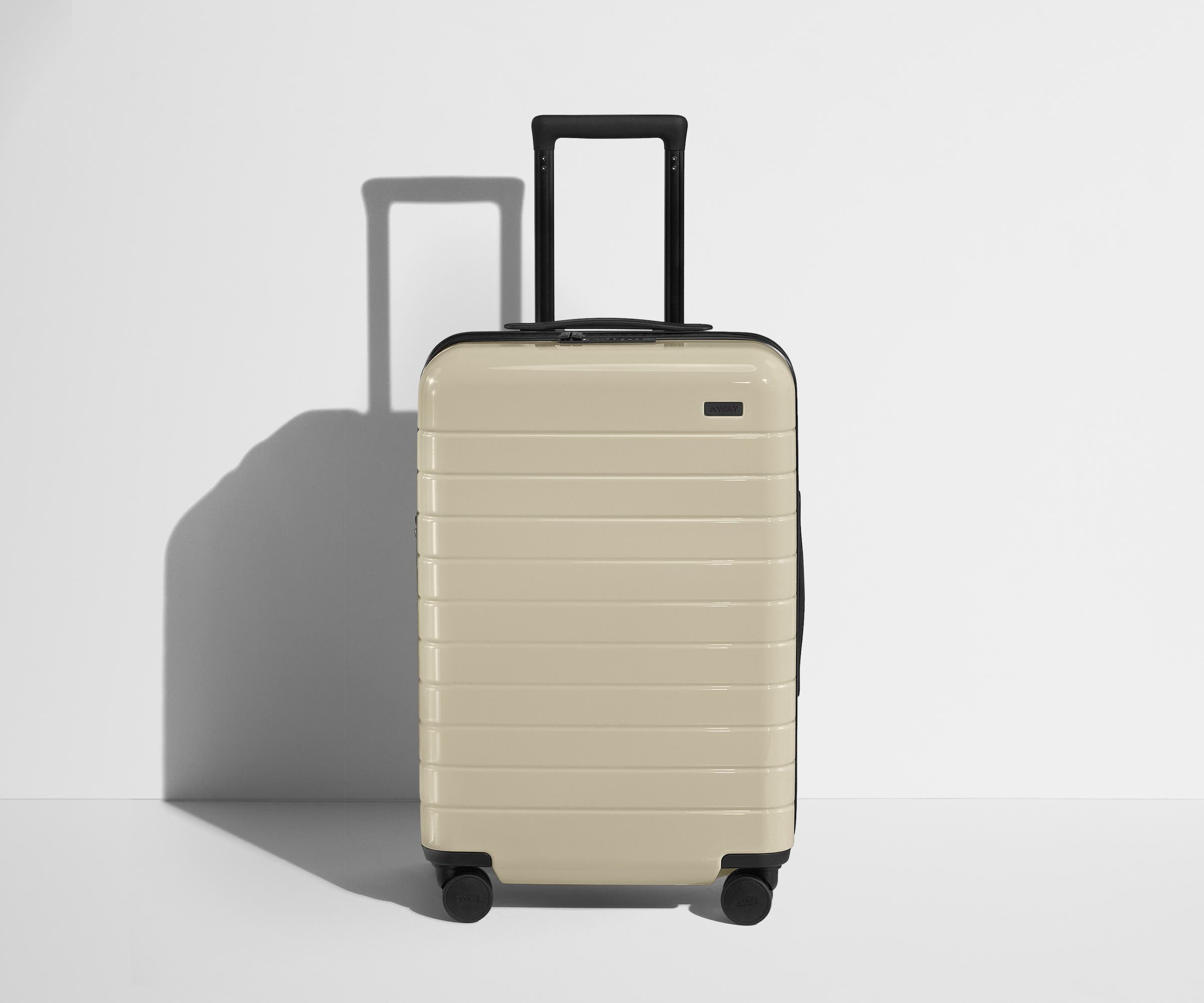 Front product view of The Bigger Carry-On Flex suitcase in Salt White (Gloss) with raised handle