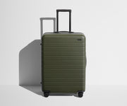 Front product view of The Medium suitcase in Olive Green with raised handle