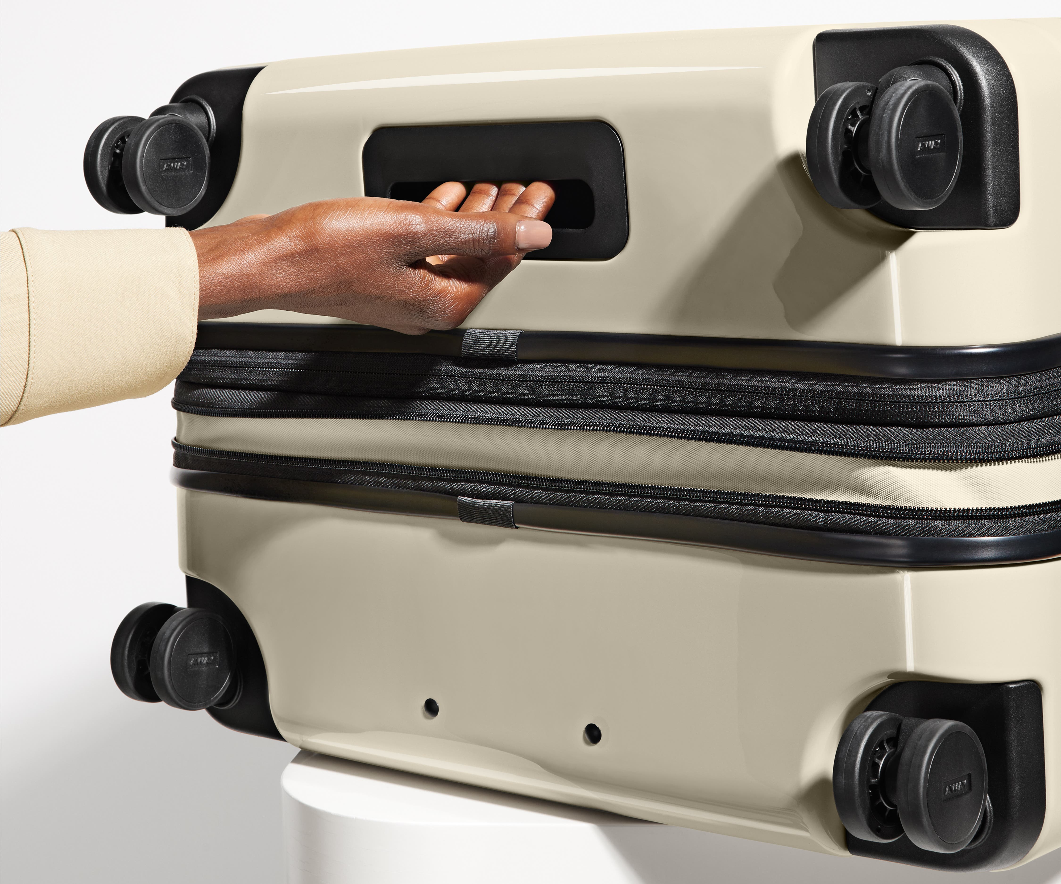 The Large Flex suitcase in Salt White (Gloss) shown from below highlighting the underside grab handle