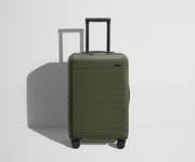 Front product view of The Bigger Carry-On Flex suitcase in Olive Green with raised handle