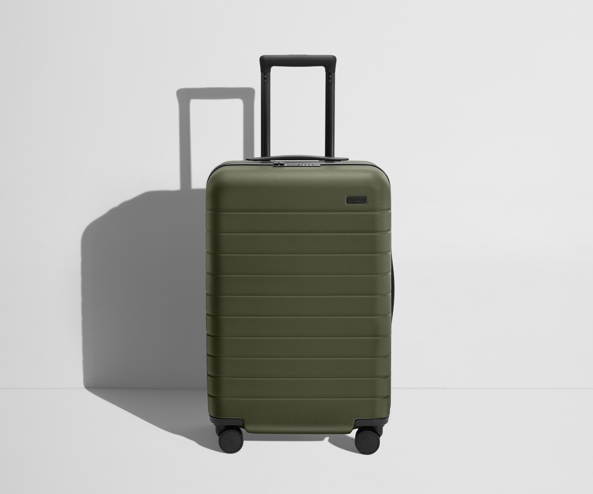 Front product view of The Bigger Carry-On Flex suitcase in Olive Green with raised handle