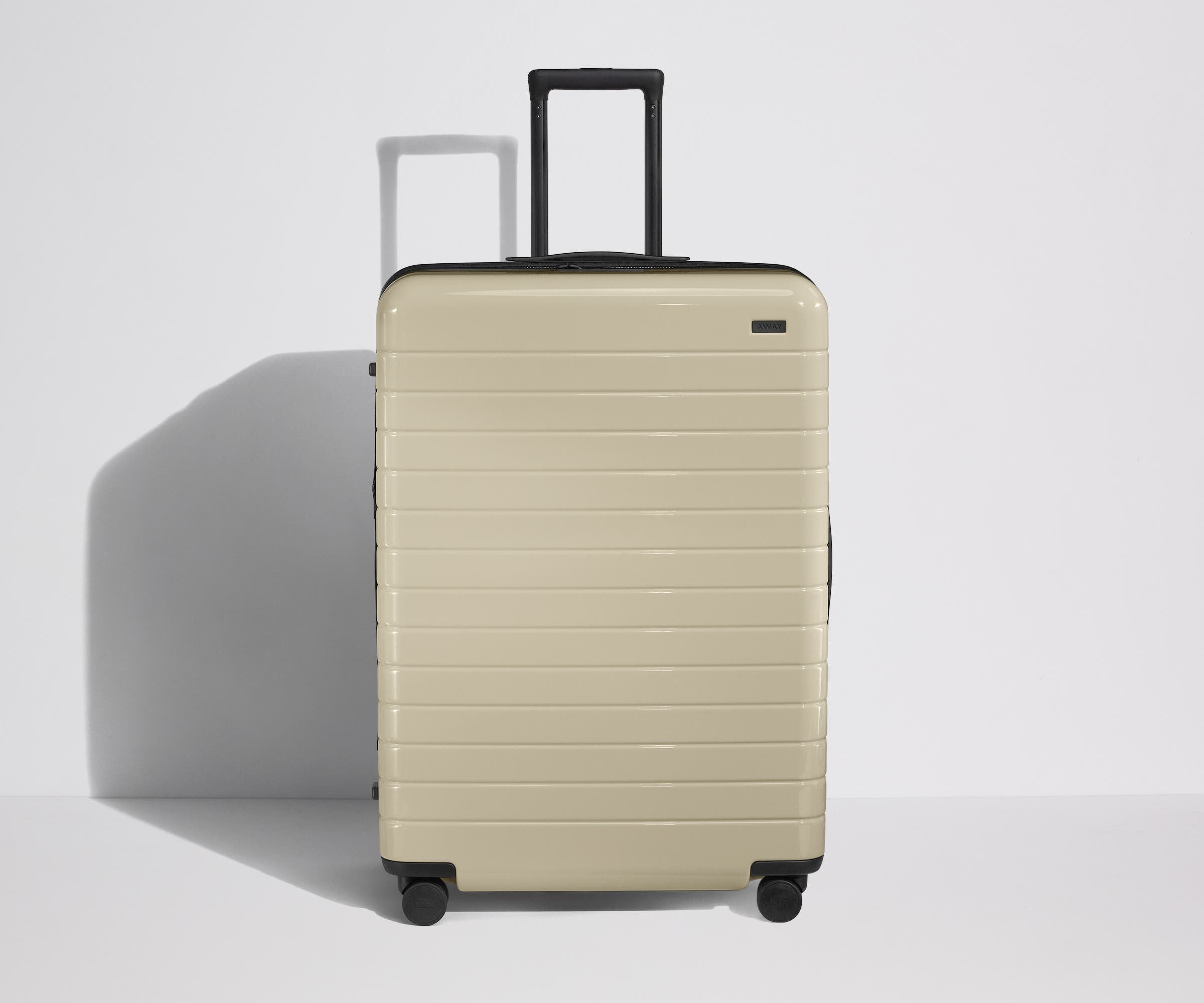 Front product view of The Large Flex suitcase in Salt White (Gloss) with raised handle