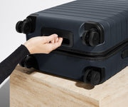 The Bigger Carry-On suitcase in Navy Blue shown from below highlighting the underside grab handle
