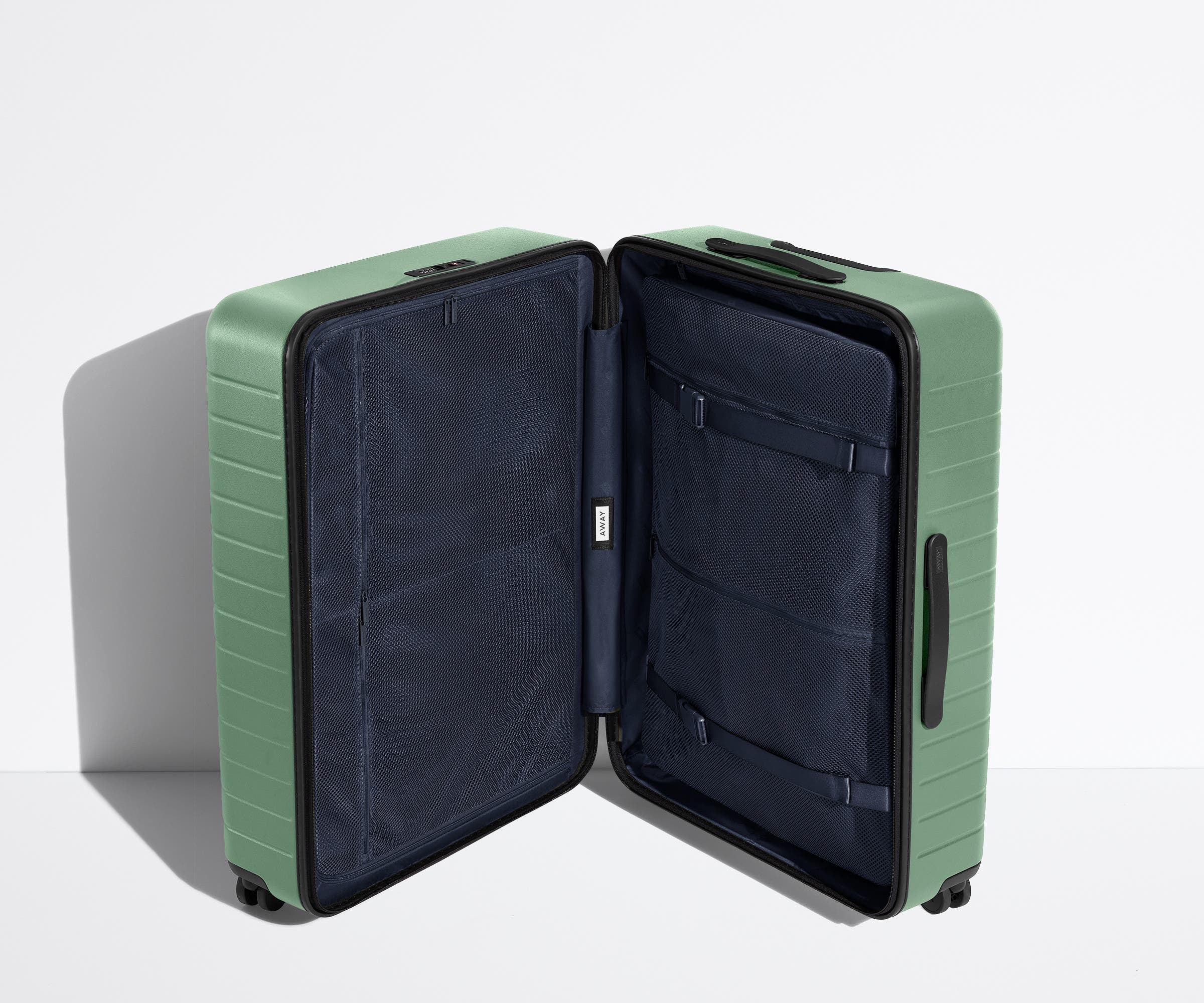 The Large suitcase in Sea Green shown open in an upright position to show interior organization and compression system