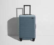 Front product view of The Bigger Carry-On Flex suitcase in Coast Blue with raised handle