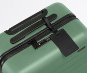 The Bigger Carry-On suitcase in Sea Green shown shown from above highlighting TSA-approved combination lock and recycled leather luggage tag