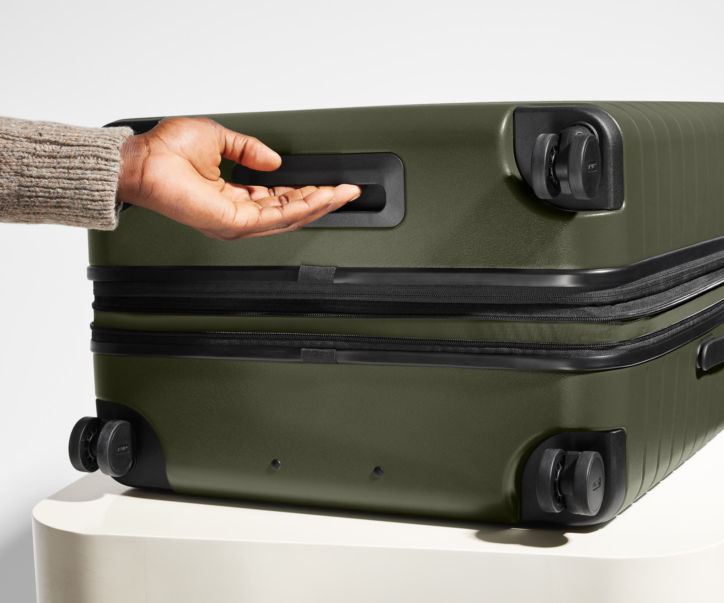 The Large Flex suitcase in Olive Green shown from below highlighting the underside grab handle