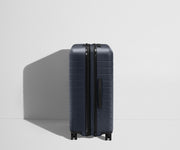 Side product view of The Medium Flex suitcase in Navy Blue shown fully expanded