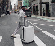 Influencer @mcarthurjoseph walking down a city crosswalk with The Large in Cloud Gray