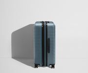 Side product view of The Medium Flex suitcase in Coast Blue shown fully expanded