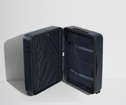 The Medium suitcase in Coast Blue shown open in an upright position to show interior organization and compression system