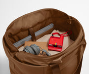 Interior packed with clothing, a laptop, headphones, notebook, and camera