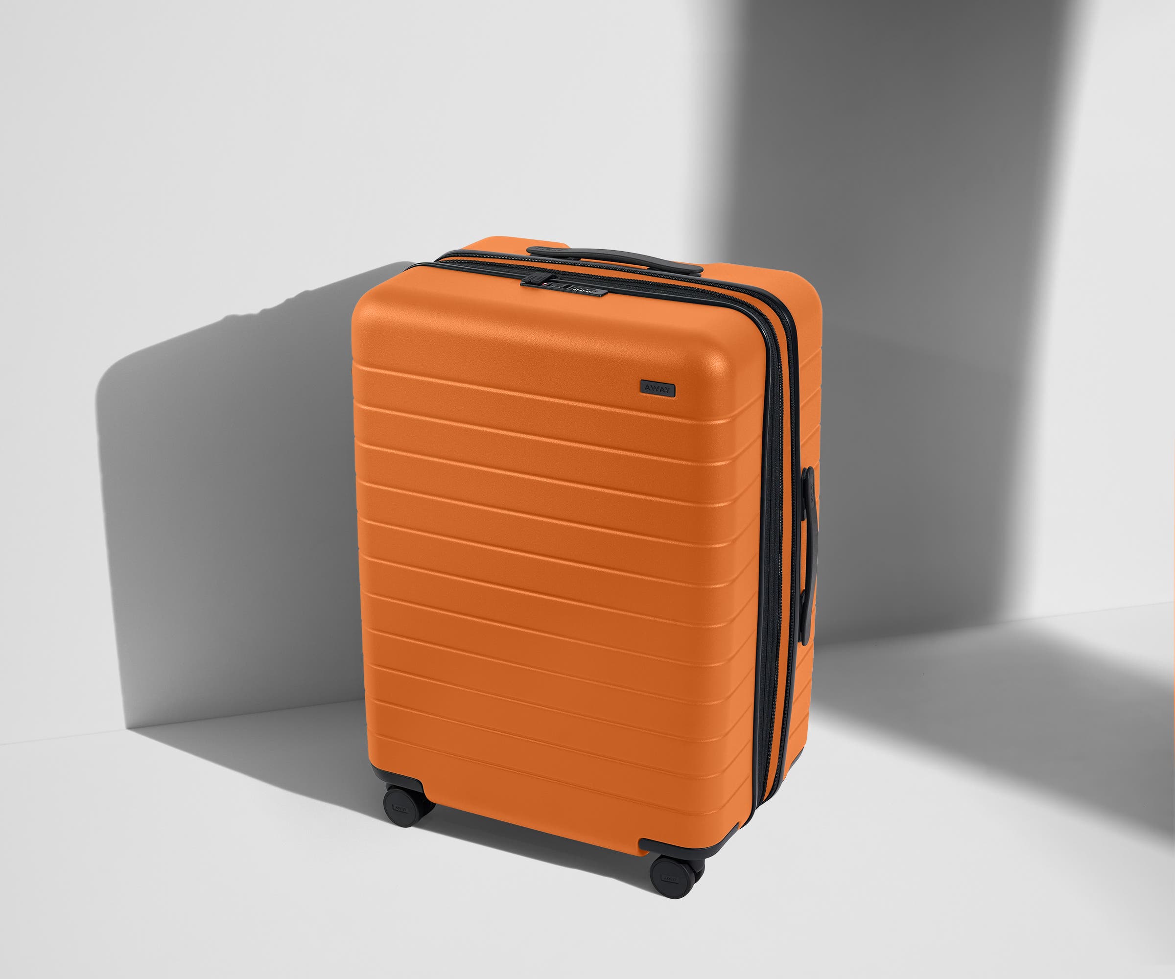 Angled product view of The Medium Flex suitcase in Sorbet Orange