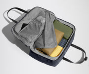 Open clamshell Weekender bag packed with travel essentials, including clothes and Small Toiletry Bag