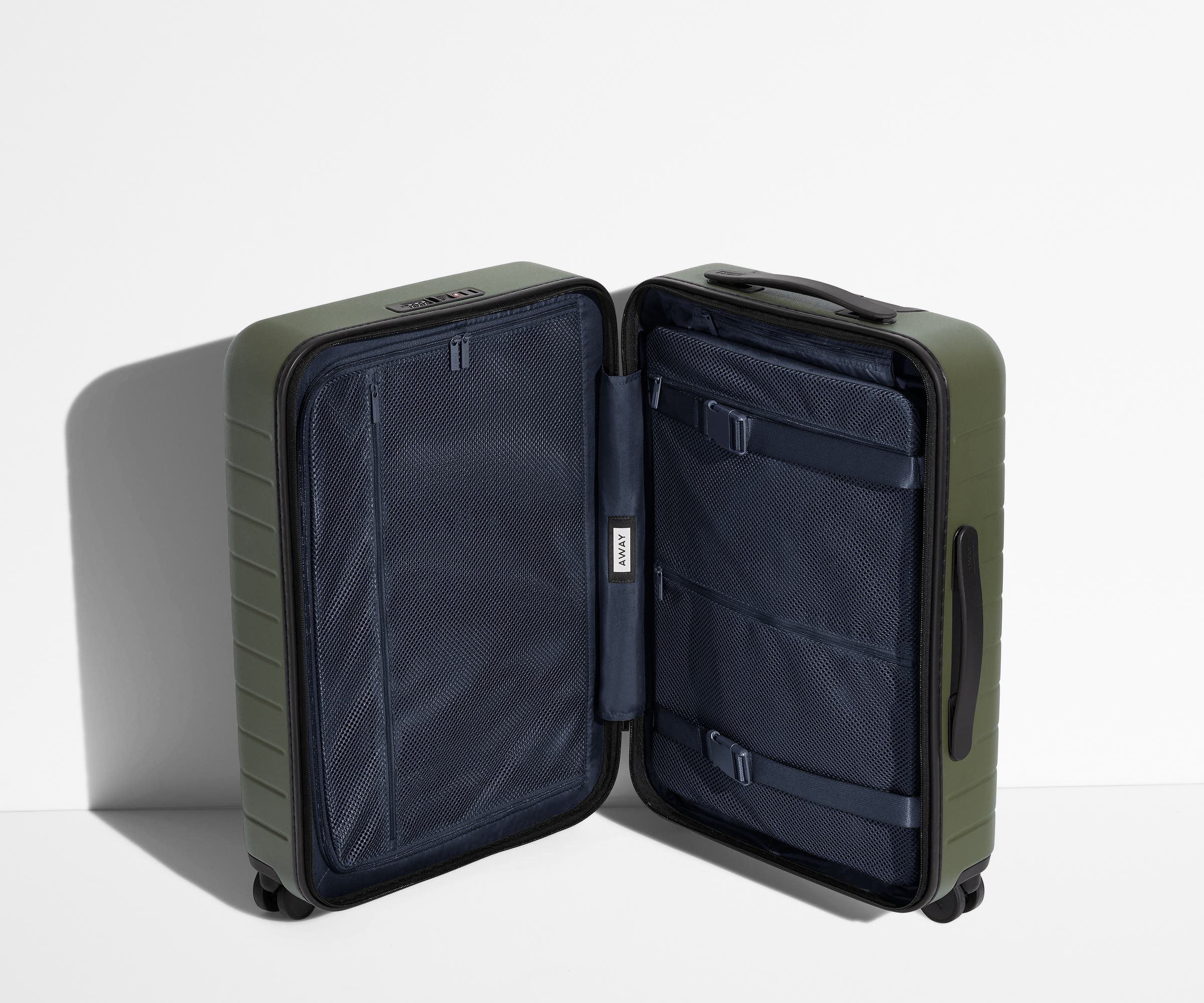 The Carry-On suitcase in Olive Green shown open in an upright position to show interior organization and compression system