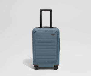 Front product view of The Front Carry-On suitcase in Coast Blue with raised handle