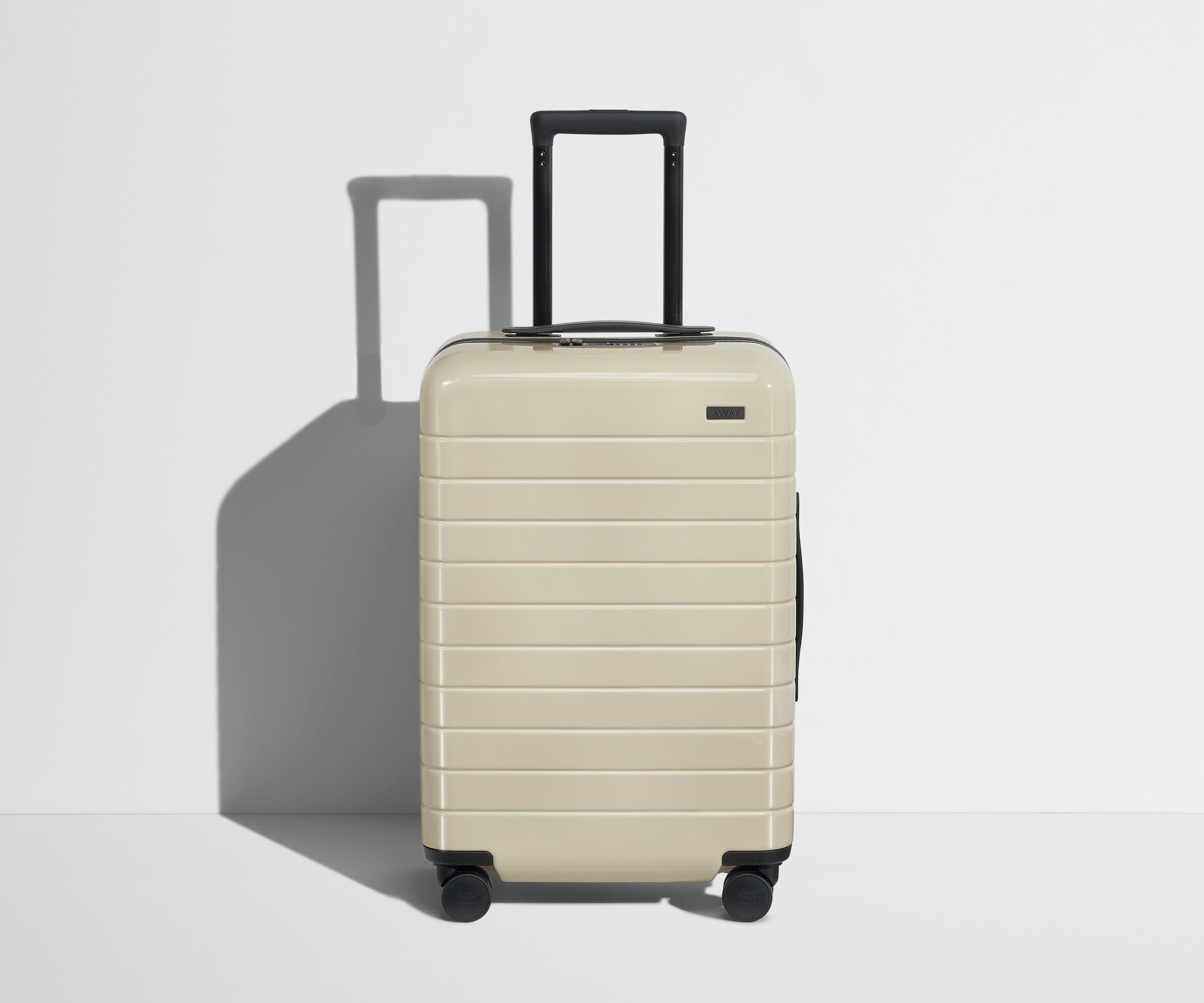 Front product view of The Bigger Carry-On suitcase in Salt White (Gloss) with raised handle