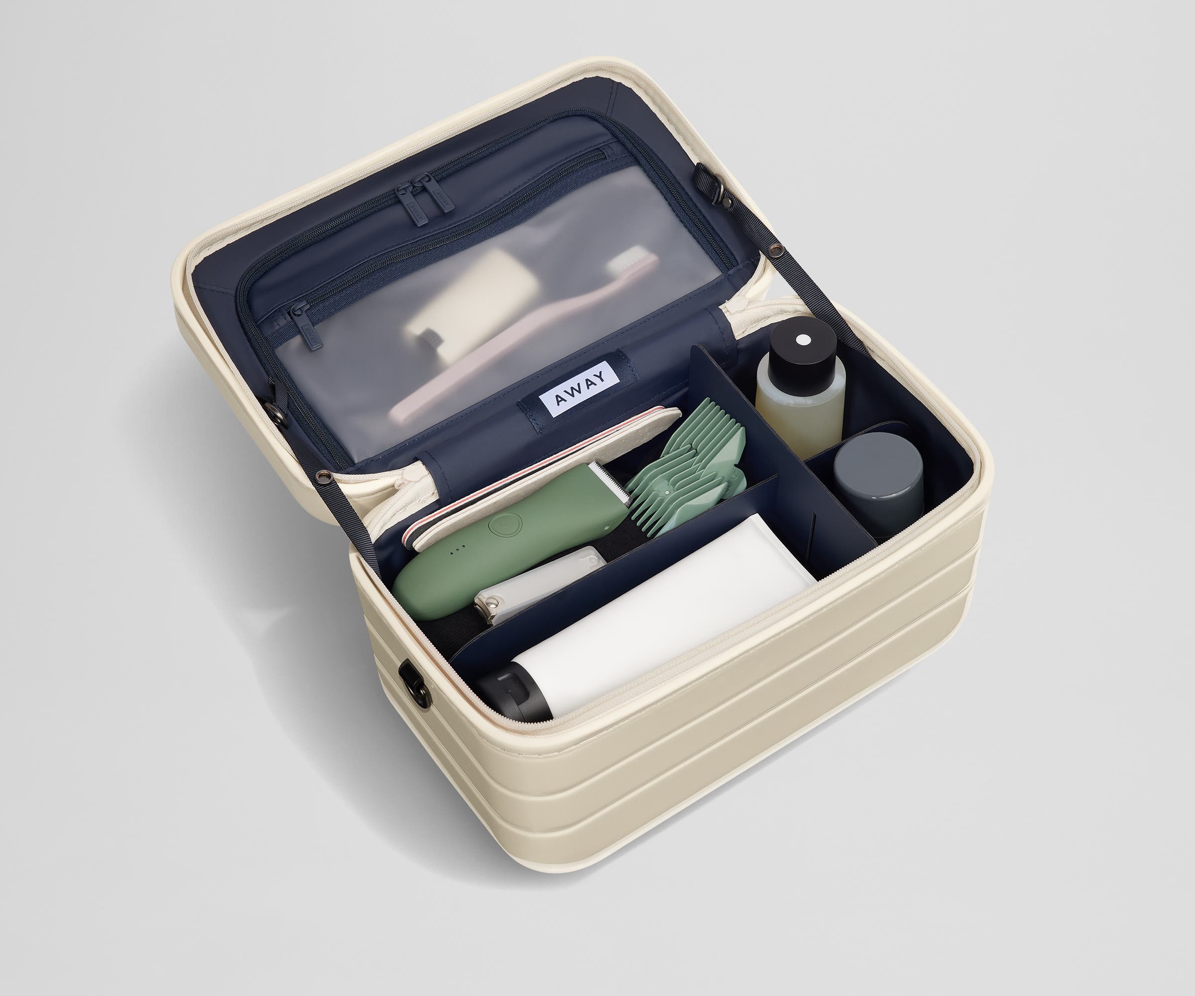 Train case packed with multiple grooming essentials, including a razor, nail care, and lotions