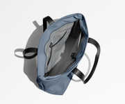 Unzipped and unpacked Everywhere Tote bag, showing the interior zip pockets, slip pockets, and laptop pocket