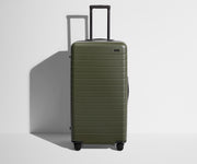 Front product view of The Trunk suitcase in Olive Green with raised handle