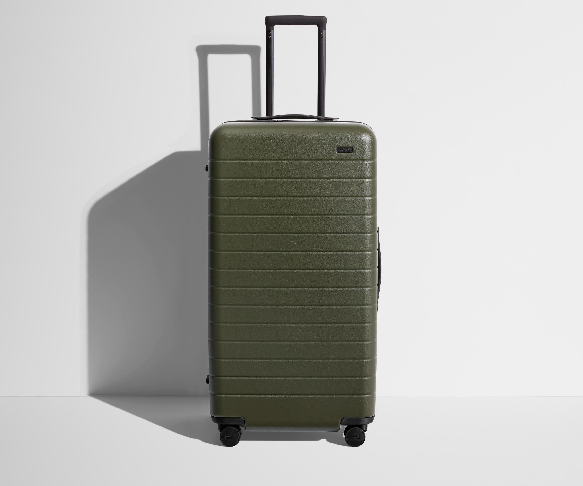 Front product view of The Trunk suitcase in Olive Green with raised handle