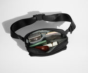 Main compartment packed with a camera, money, earpods, and other daily essentials