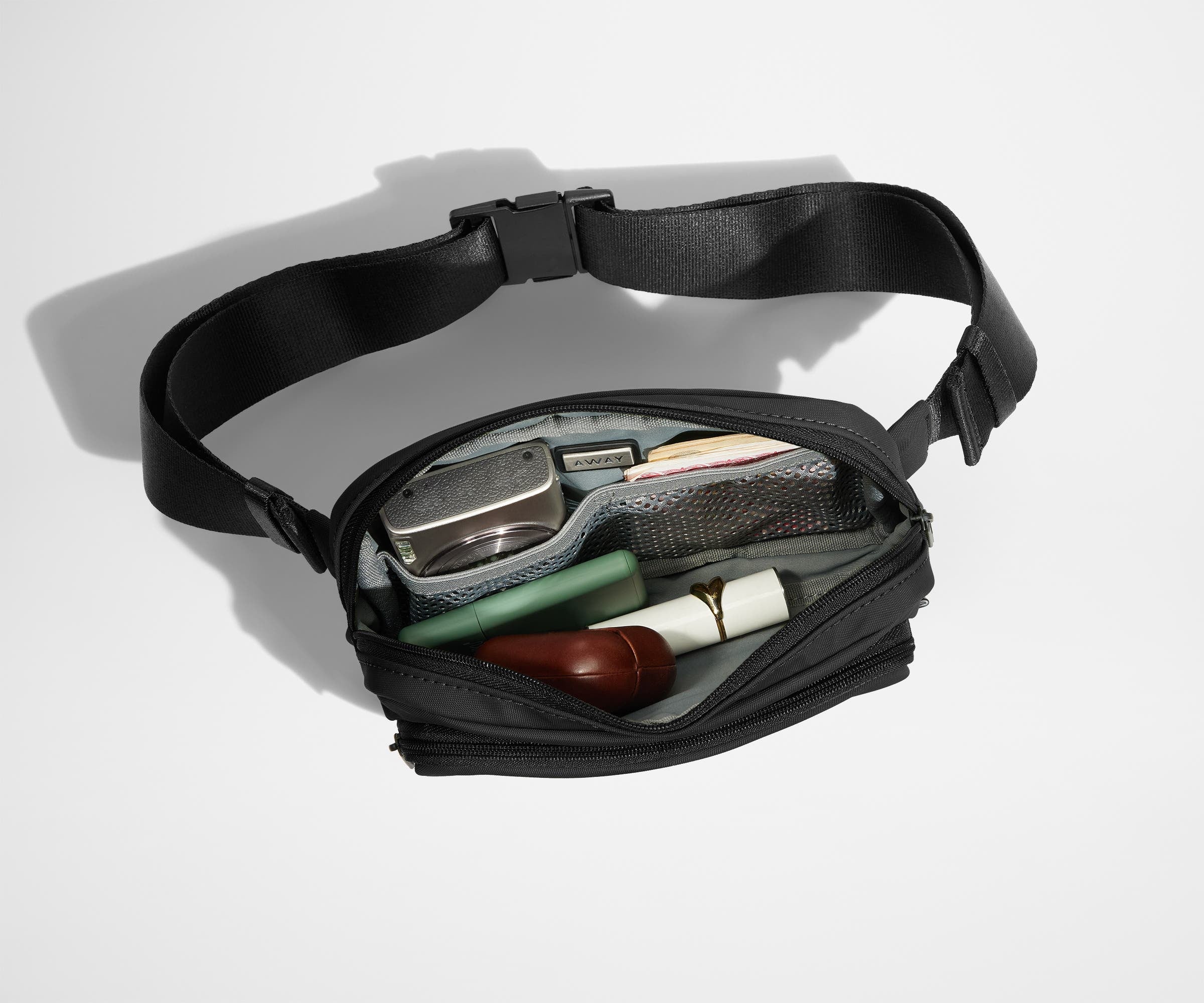 Main compartment packed with a camera, money, earpods, and other daily essentials