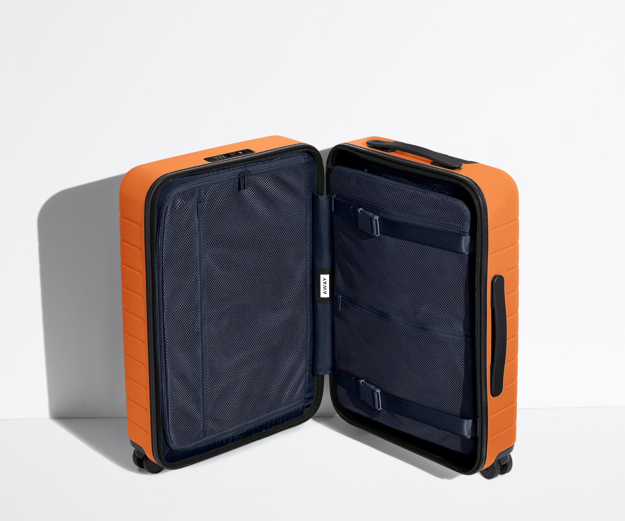 The Carry-On suitcase in Sorbet Orange shown open in an upright position to show interior organization and compression system
