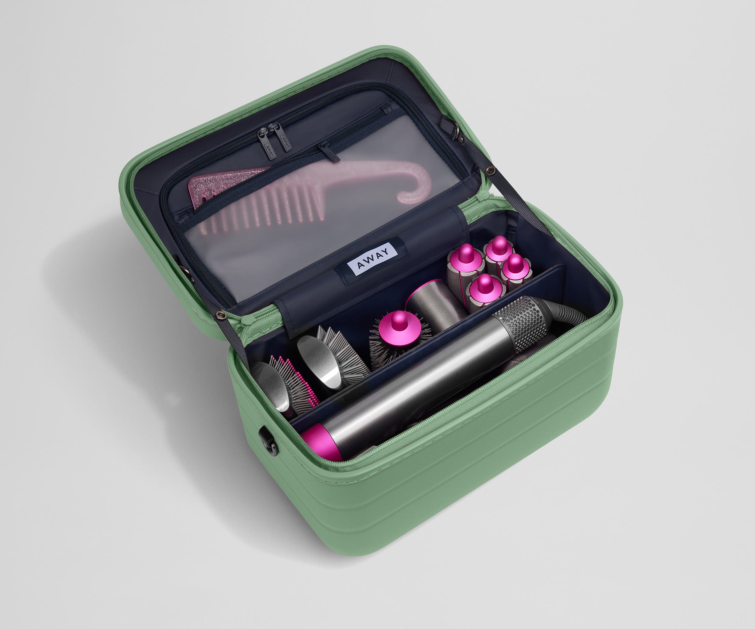 Train case packed with hair tools including a blow dryer and its attachments and a Brush