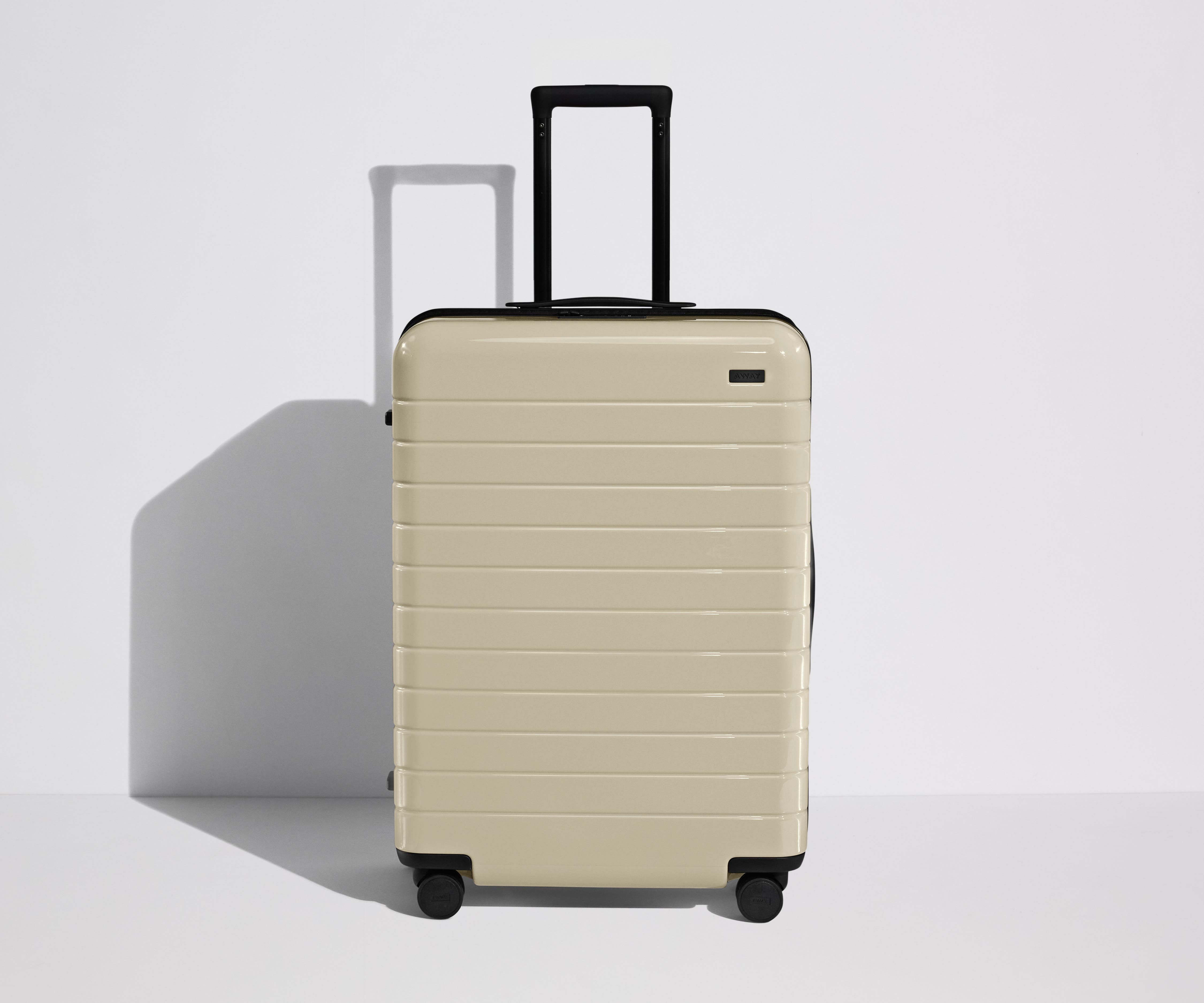 Front product view of The Medium Flex suitcase in Salt White (Gloss) with raised handle