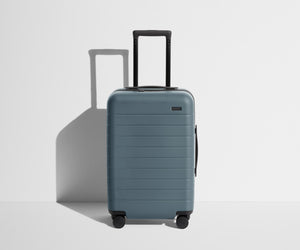 Front product view of The Carry-On suitcase in Coast Blue with raised handle