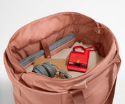 Interior packed with clothing, a laptop, headphones, notebook, and camera