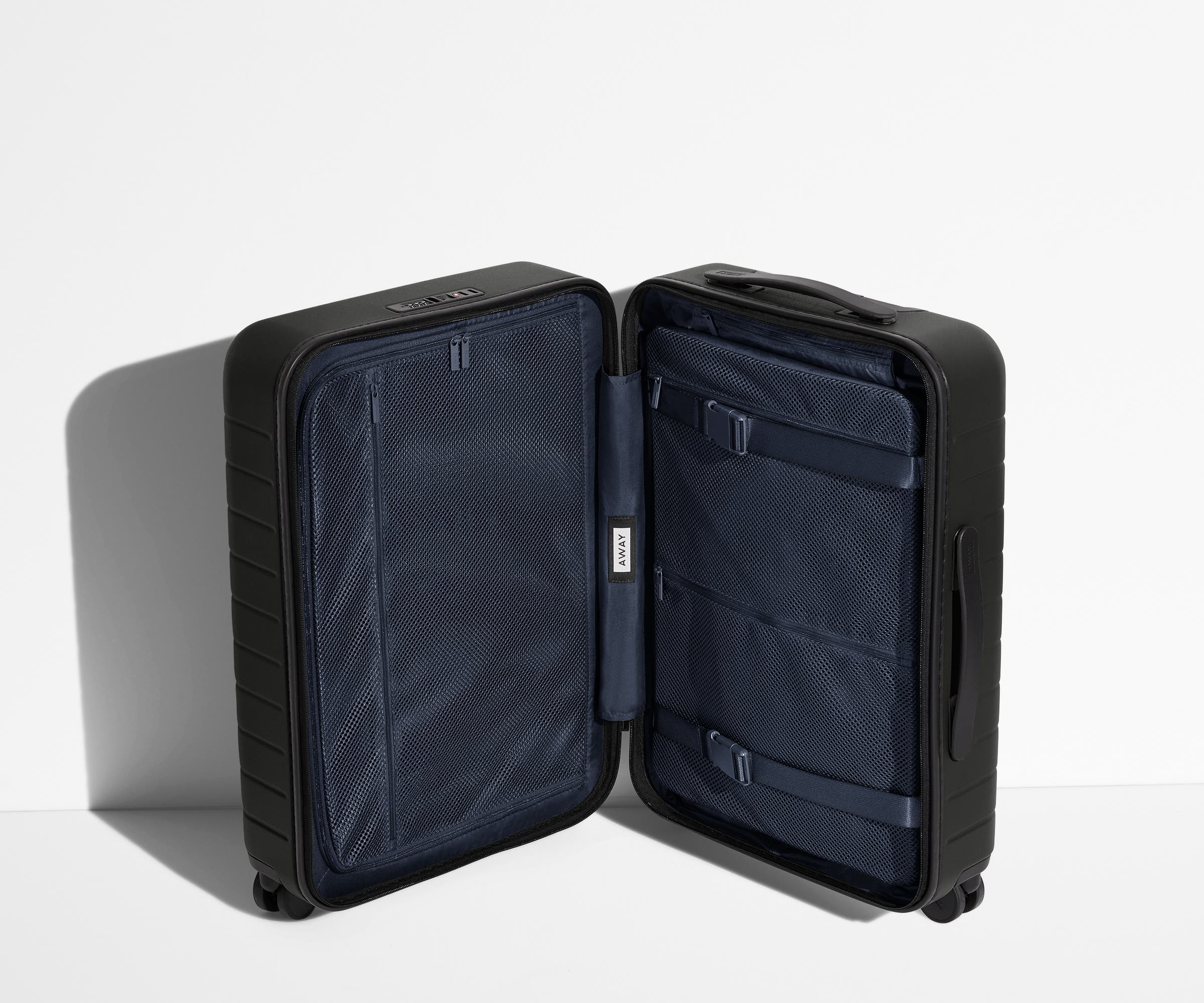 The Carry-On suitcase in Jet Black shown open in an upright position to show interior organization and compression system