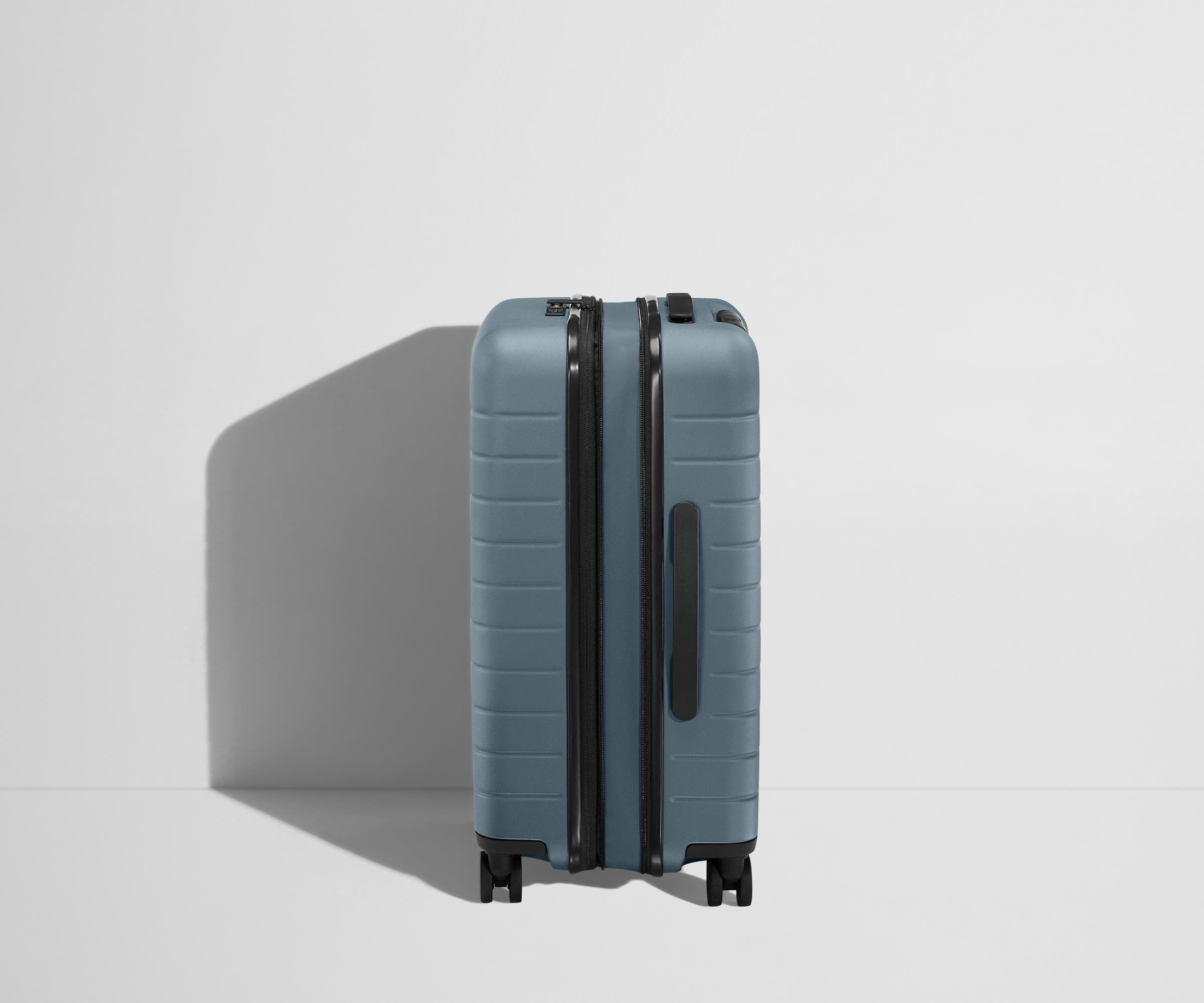 Side product view of The Bigger Carry-On Flex suitcase in Coast Blue shown fully expanded