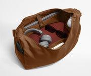 Large Featherlight Crossbody packed with clothes, a laptop, notebook, water bottle, headphones, and sunglasses