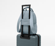 Featherlight Backpack on top of an Away suitcase, attached by the trolley sleeve