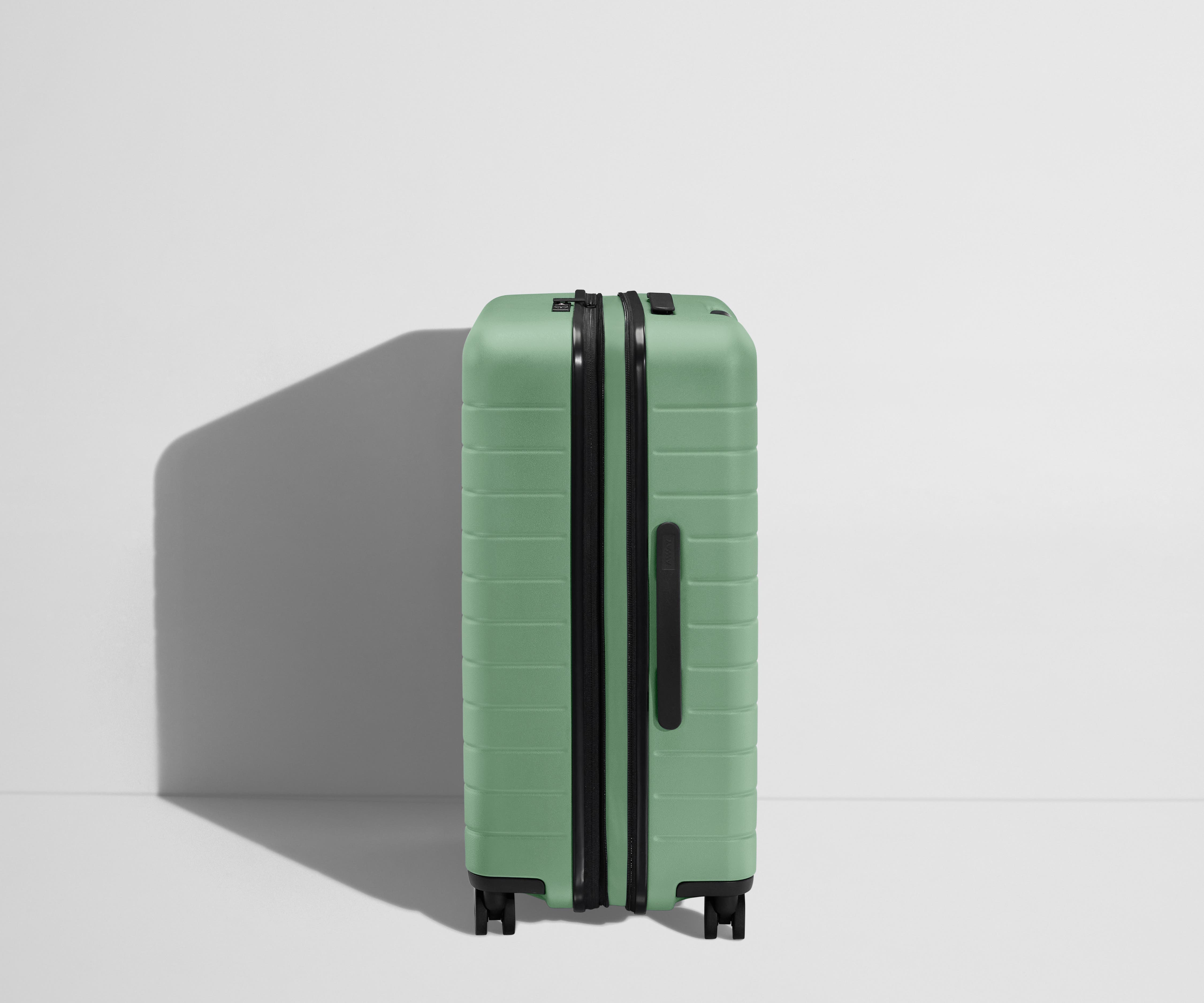 Side product view of The Medium Flex suitcase in Sea Green shown fully expanded