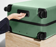 The Large suitcase in Sea Green shown from below highlighting the underside grab handle