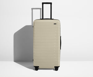 Front product view of The Trunk suitcase in Salt White (Gloss) with raised handle