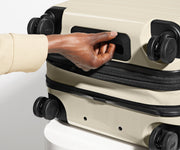 The Carry-On Flex suitcase in Salt White (Gloss) shown from below highlighting the underside grab handle